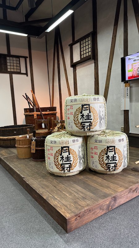 Three traditional white sake containers piled up on top of each other.