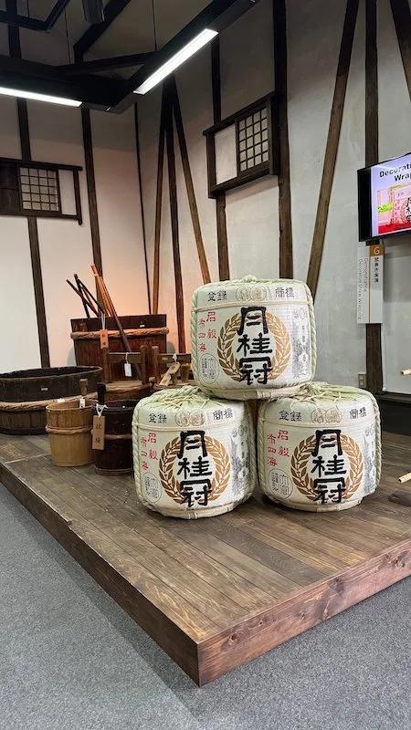 Three traditional white sake containers piled up on top of each other.