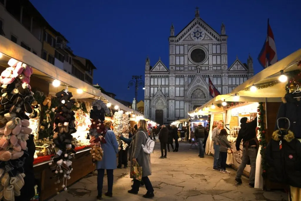 A Christmas Market at night, and the Basilica di Santa Croce in the background