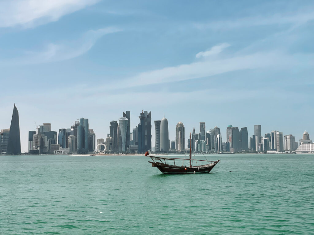 A dhow in the water, and modern skyscrapers in the background