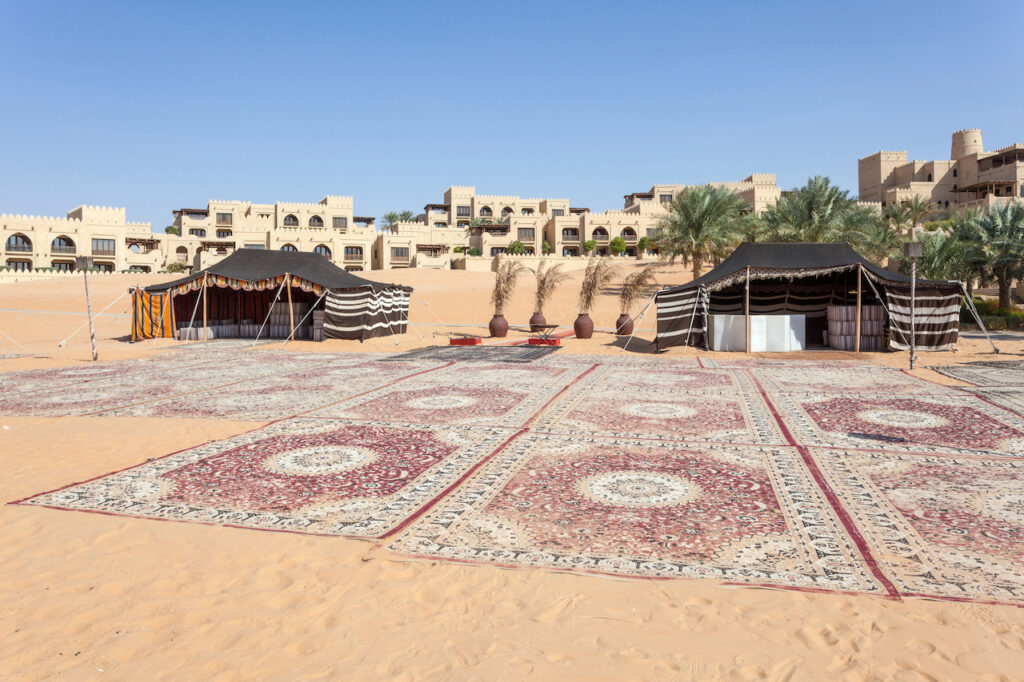 Arabic rugs and traditional desert tents in front of a desert resort in Dubai.