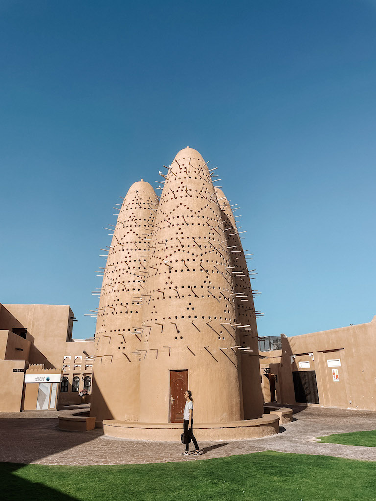 A woman standing in front of a building in Katara Cultural Village