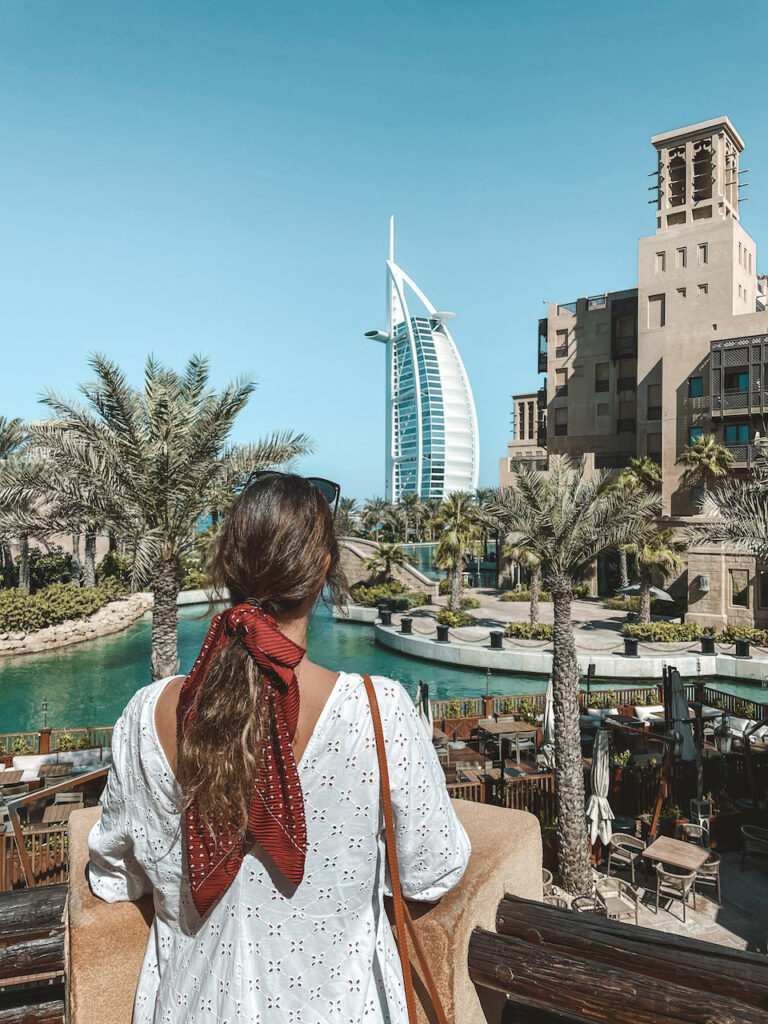 A woman seen from behind overlooking the Burj Al Arab building