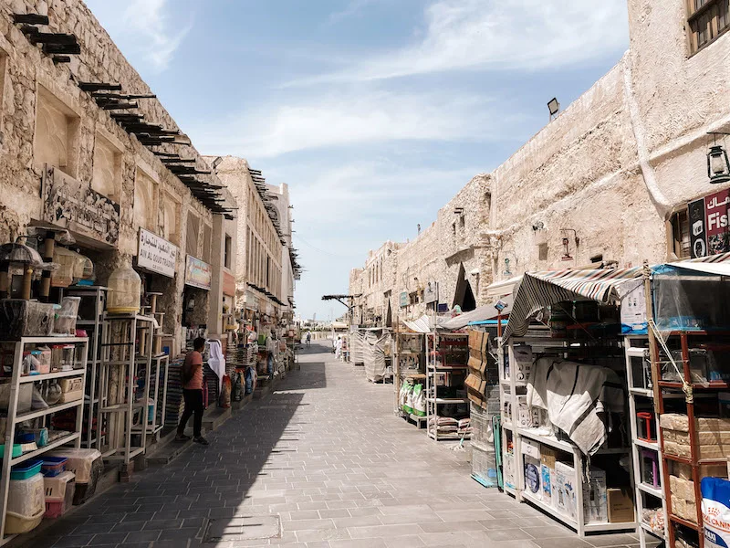 An alley lined by traditional-looking buildings and stalls in Doha