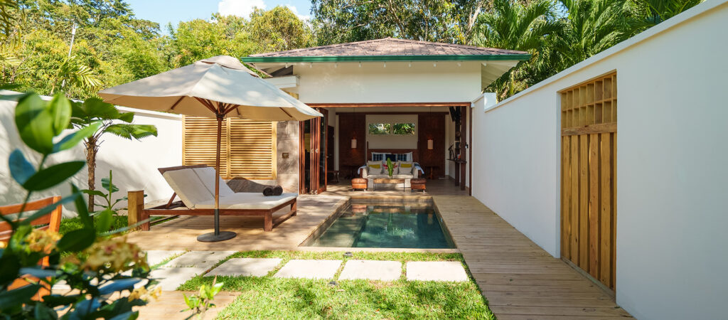 A small plunge pool with sun beds and an umbrella to the side