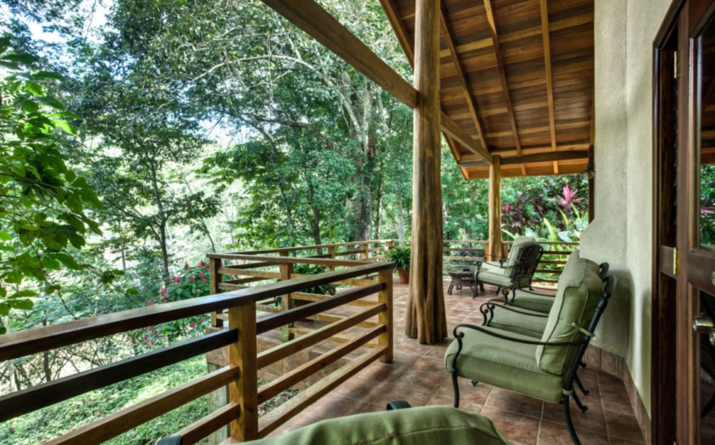 A vast terrace with green outdoor furniture overlooking the jungle