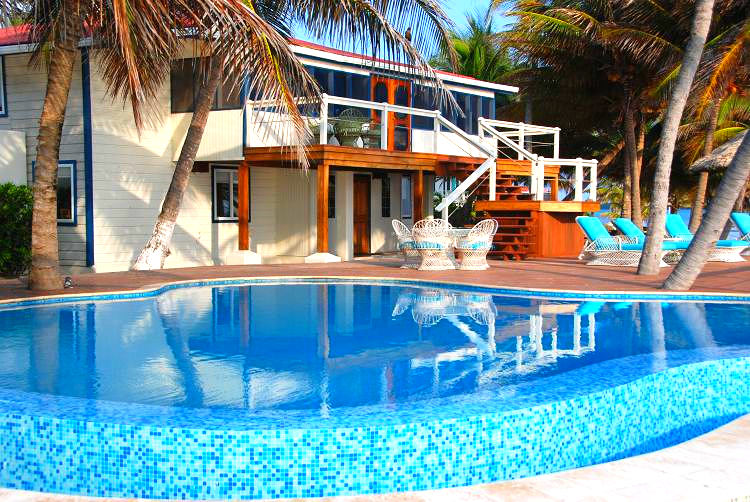 A swimming pool, and a white and blue two-story building in the background