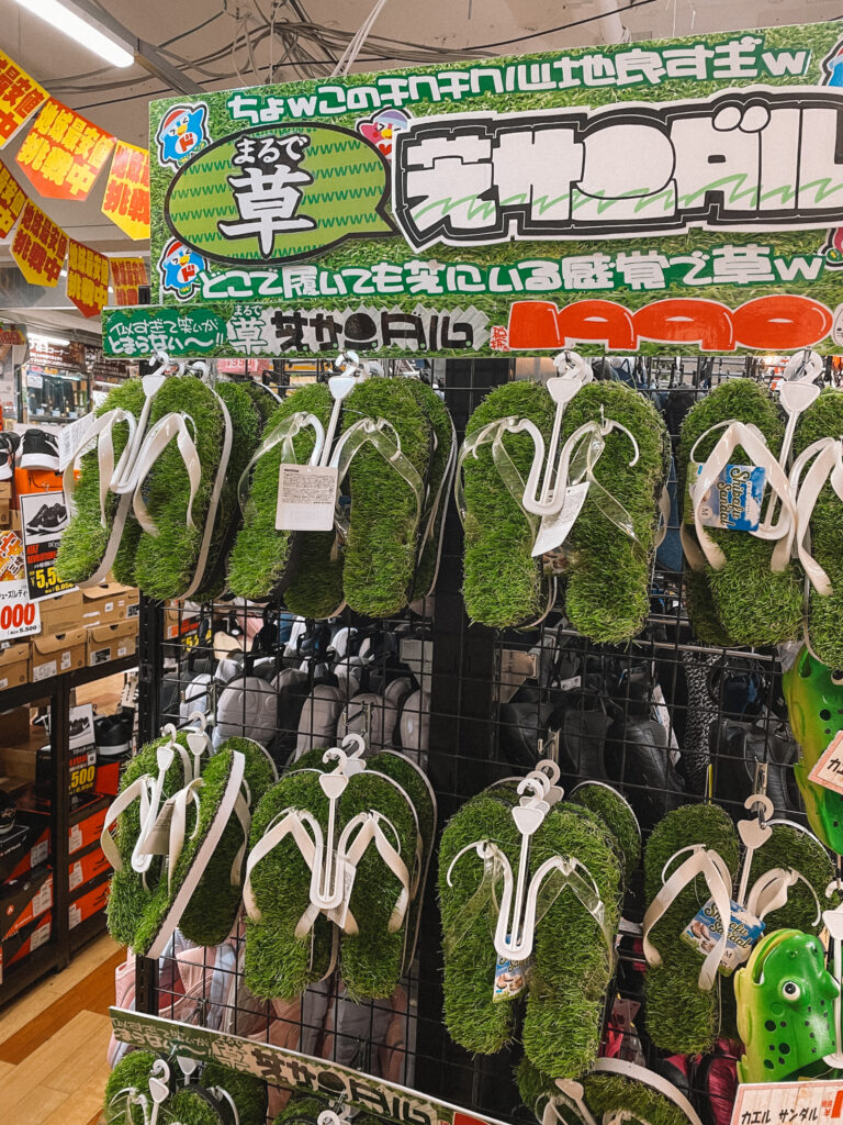 Flip flops with green, moss-like insoles on display in a store