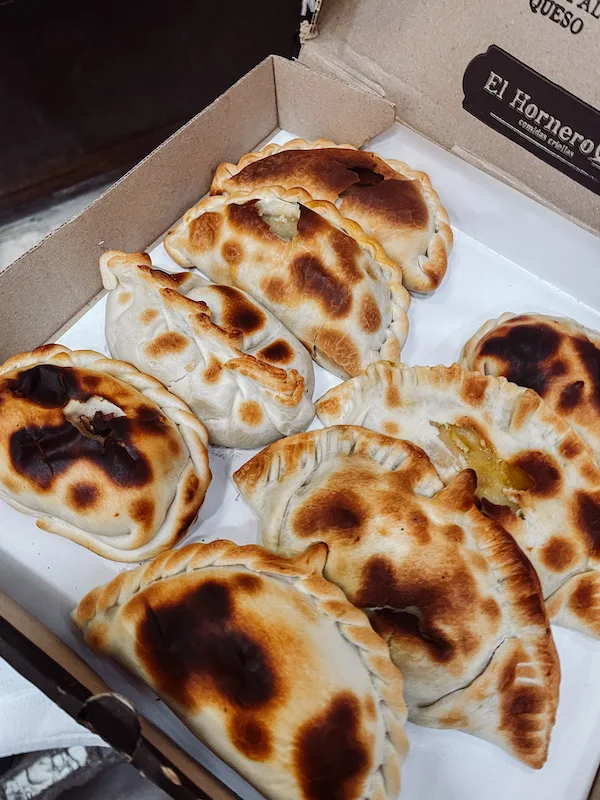 A box with eight empanadas inside