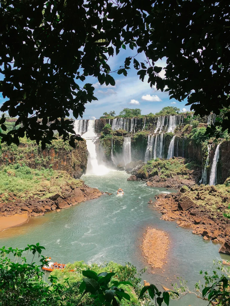 The Iguazu Waterfalls and a boat sailing in the river below them