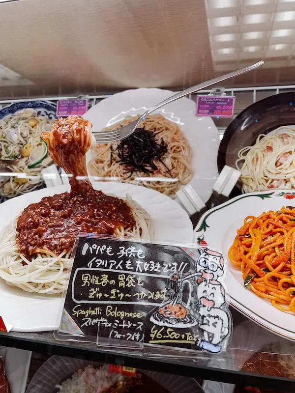 a display of plates with spaghetti and sauce, all made out of plastic