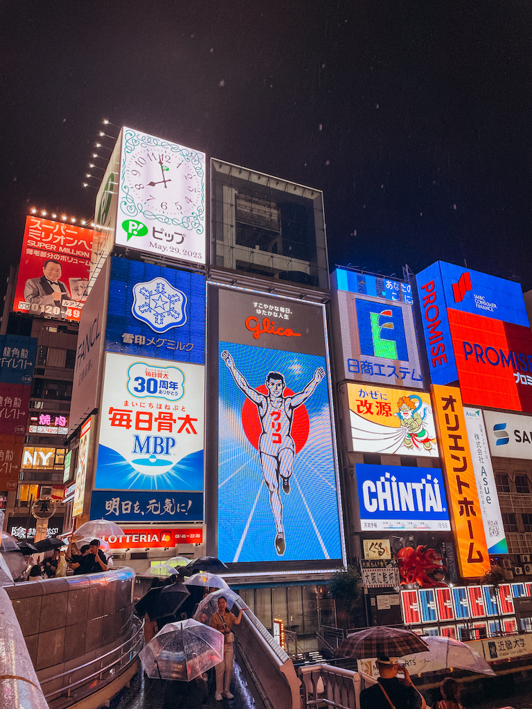 Colorful neon boards in Japanese letters, including the famous Glico sign in Osaka.