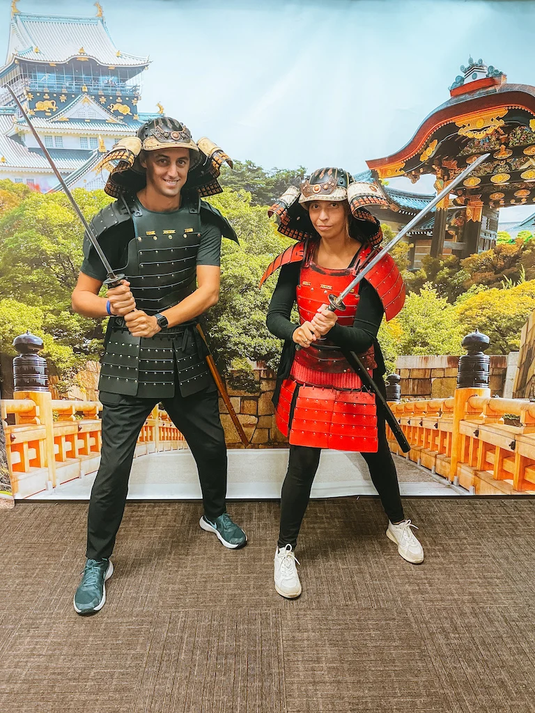 A man and a woman dressed in samurai costumes holding a sword