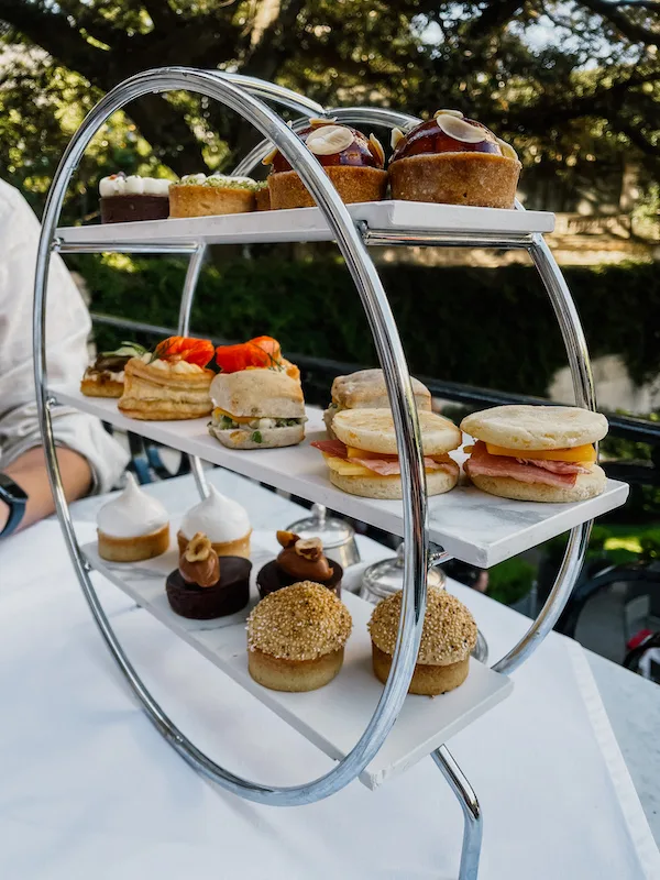 A three-tiered tray with pastries on a table 