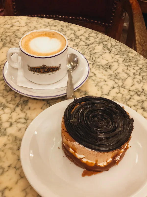 A coffee and a chocolate pastry on a  table 