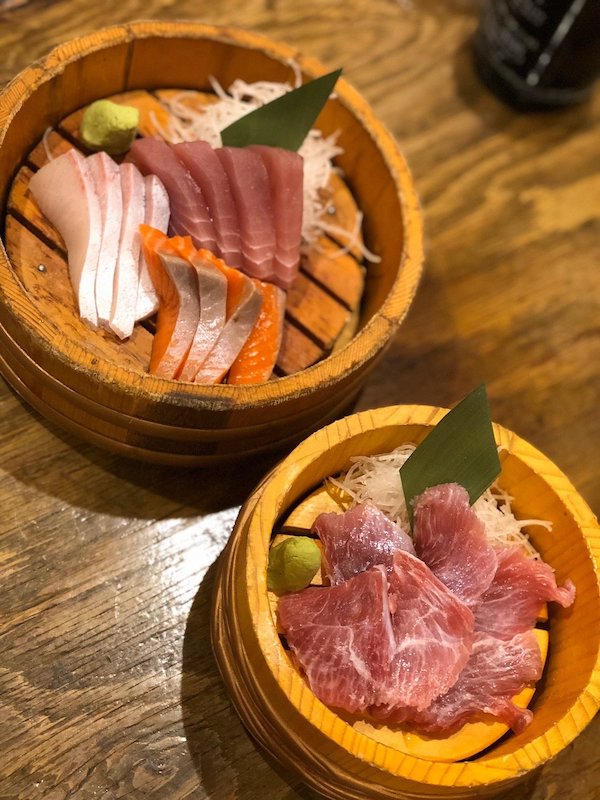 Two bamboo bowls with raw fish on a table