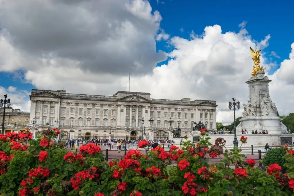 Buckingham Palace, and red flowers at the forefront of hte image