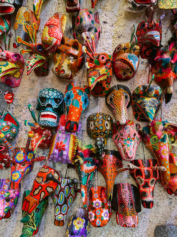 Colorful wooden masks on a wall in a market in Antigua