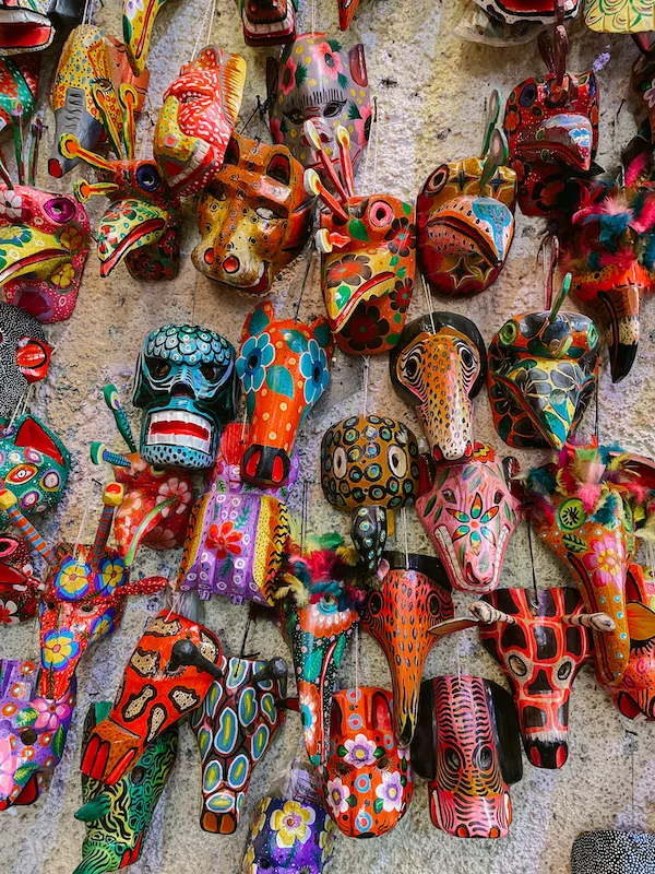 Colorful wooden masks on a wall in a market in Antigua